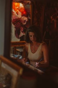 Künstlerin Sara Heinrich Fine-Art ist beim malen im eigenen Atelier zu sehen.